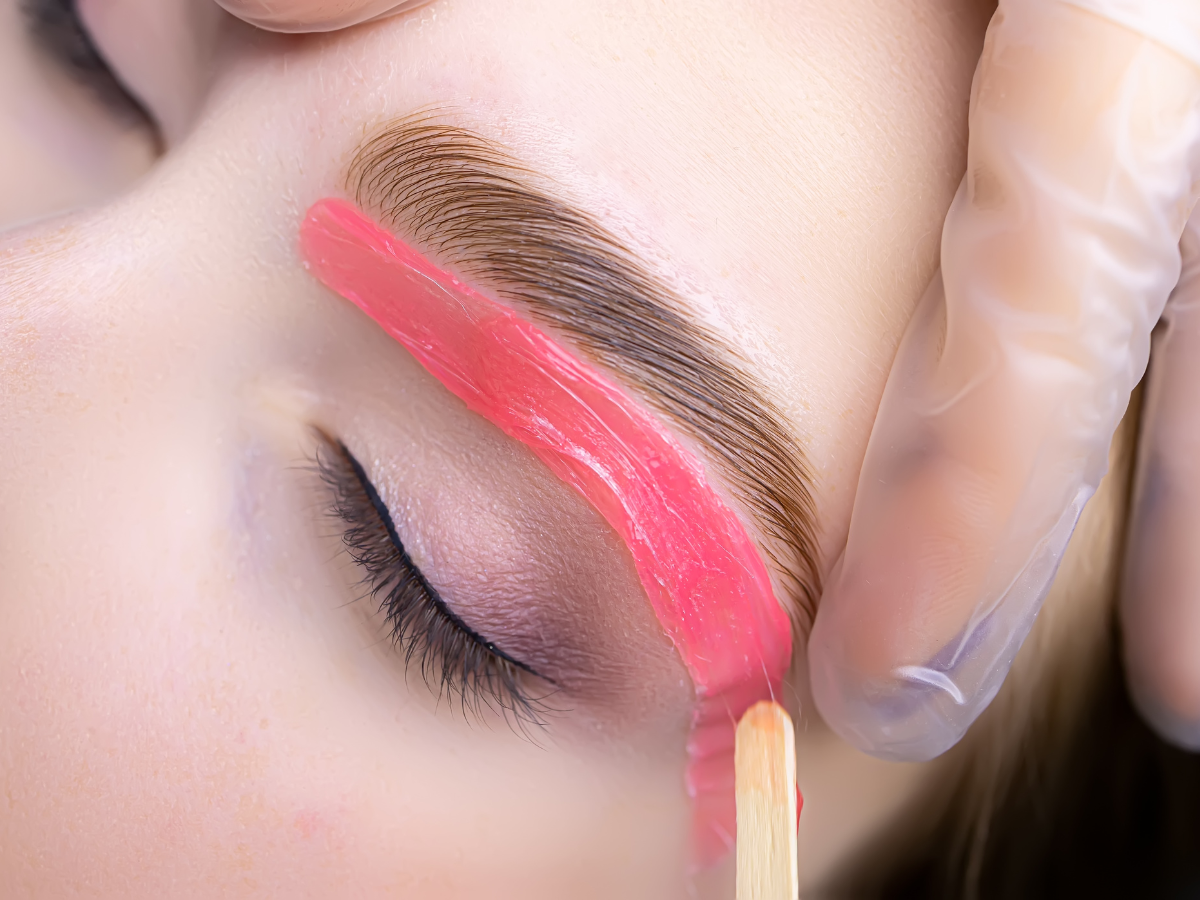 A woman is getting her eyebrows waxed in a beauty salon. A woman is getting her eyebrows waxed in a beauty salon.