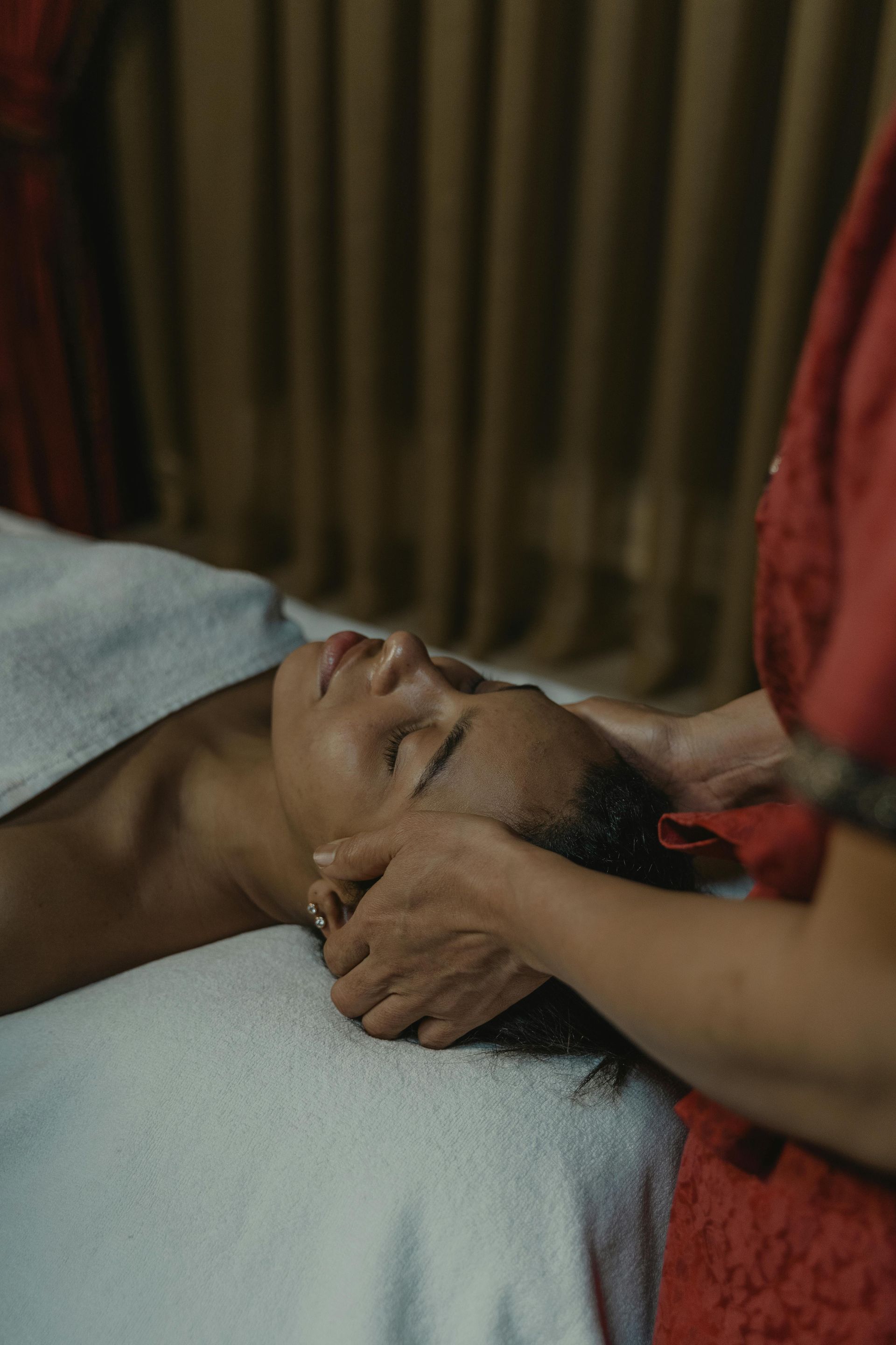 A woman is getting a head massage at a spa.