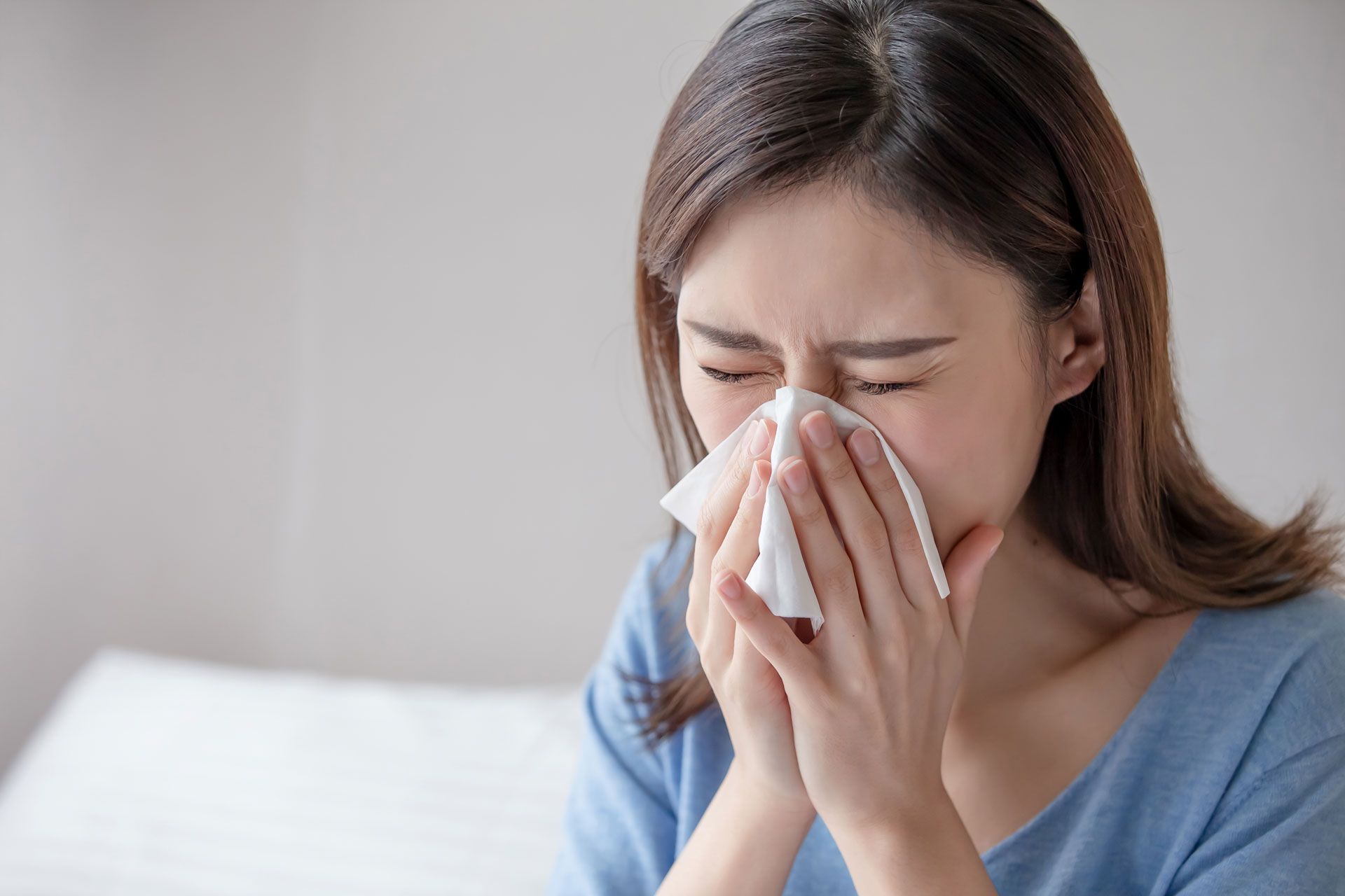 A woman is blowing her nose with a napkin.
