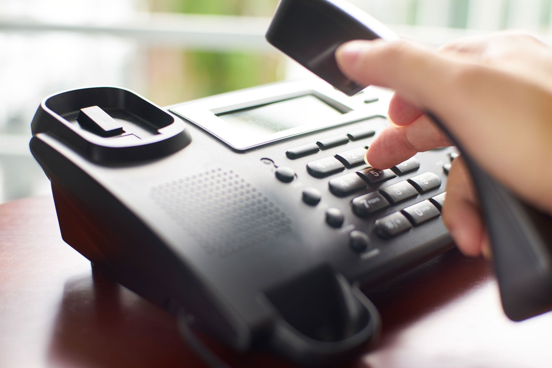 A person is dialing a number on a telephone