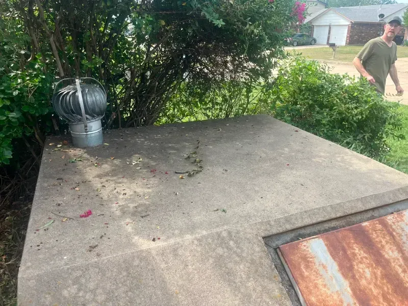 Concrete utility box with a spinning vent. A man walks in the background.