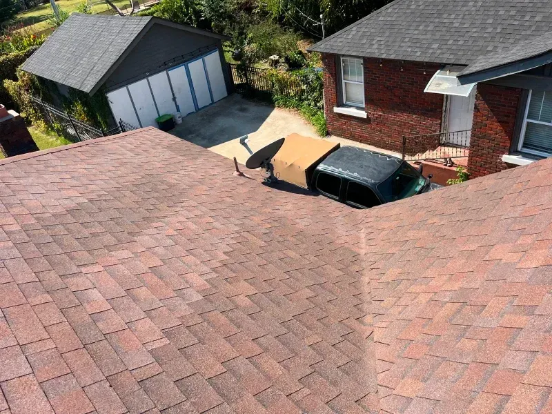 Overhead view of a house with a car parked in the driveway. The roof is brown.