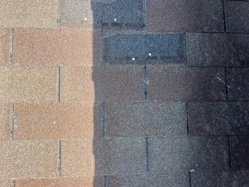 Close-up of a roof showing a color difference between weathered brown and newer tan asphalt shingles.