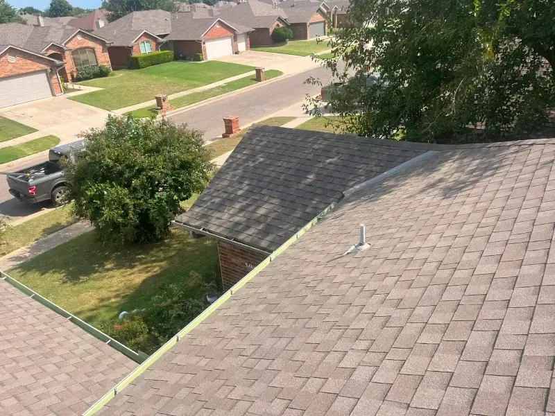 View of residential roofs and street in daylight.