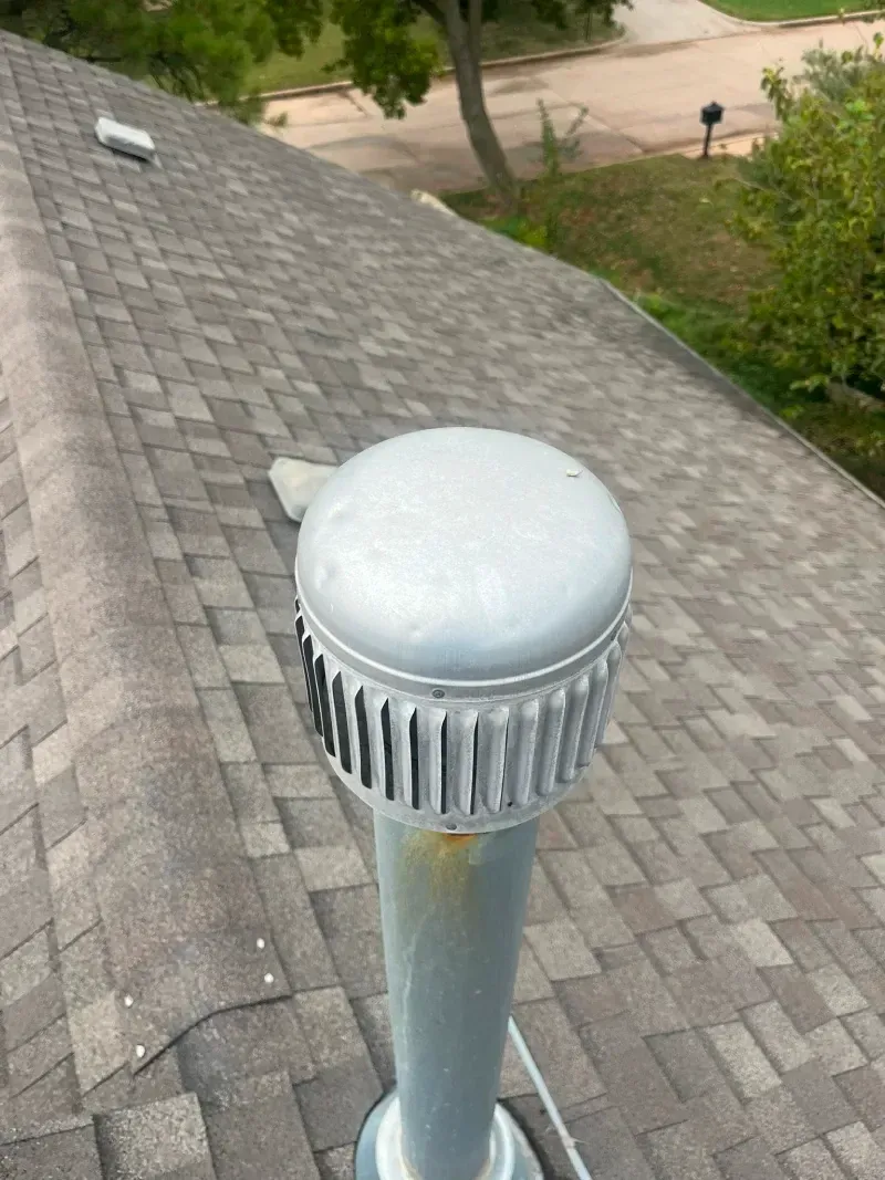 Metal roof vent on a shingled roof.