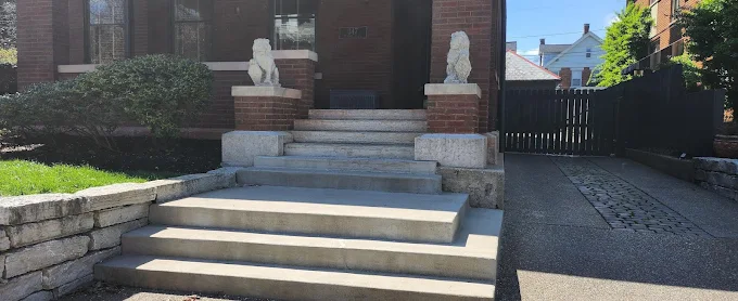 A brick house with concrete steps leading up to the front door.
