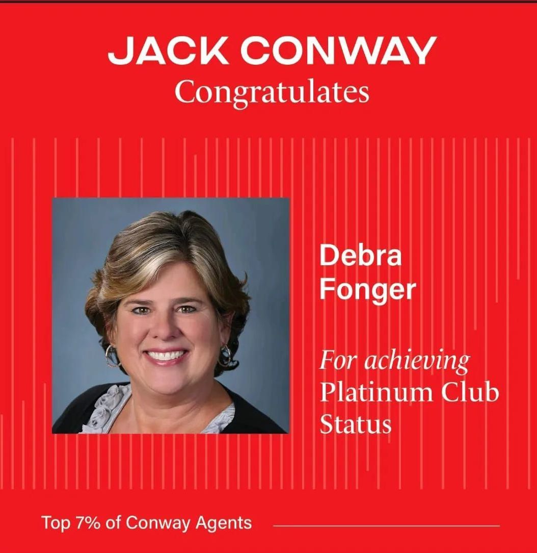 A dining room with a table and chairs and a wooden staircase.