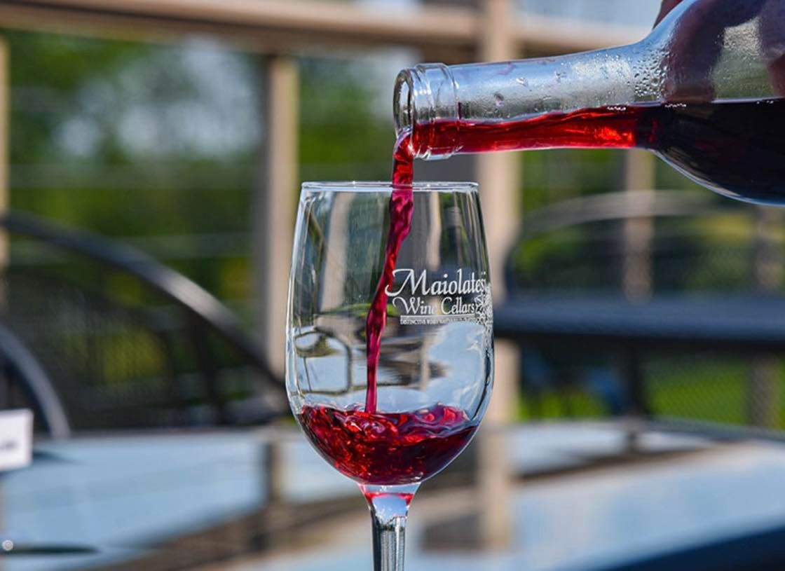 A person is pouring red wine into a glass.