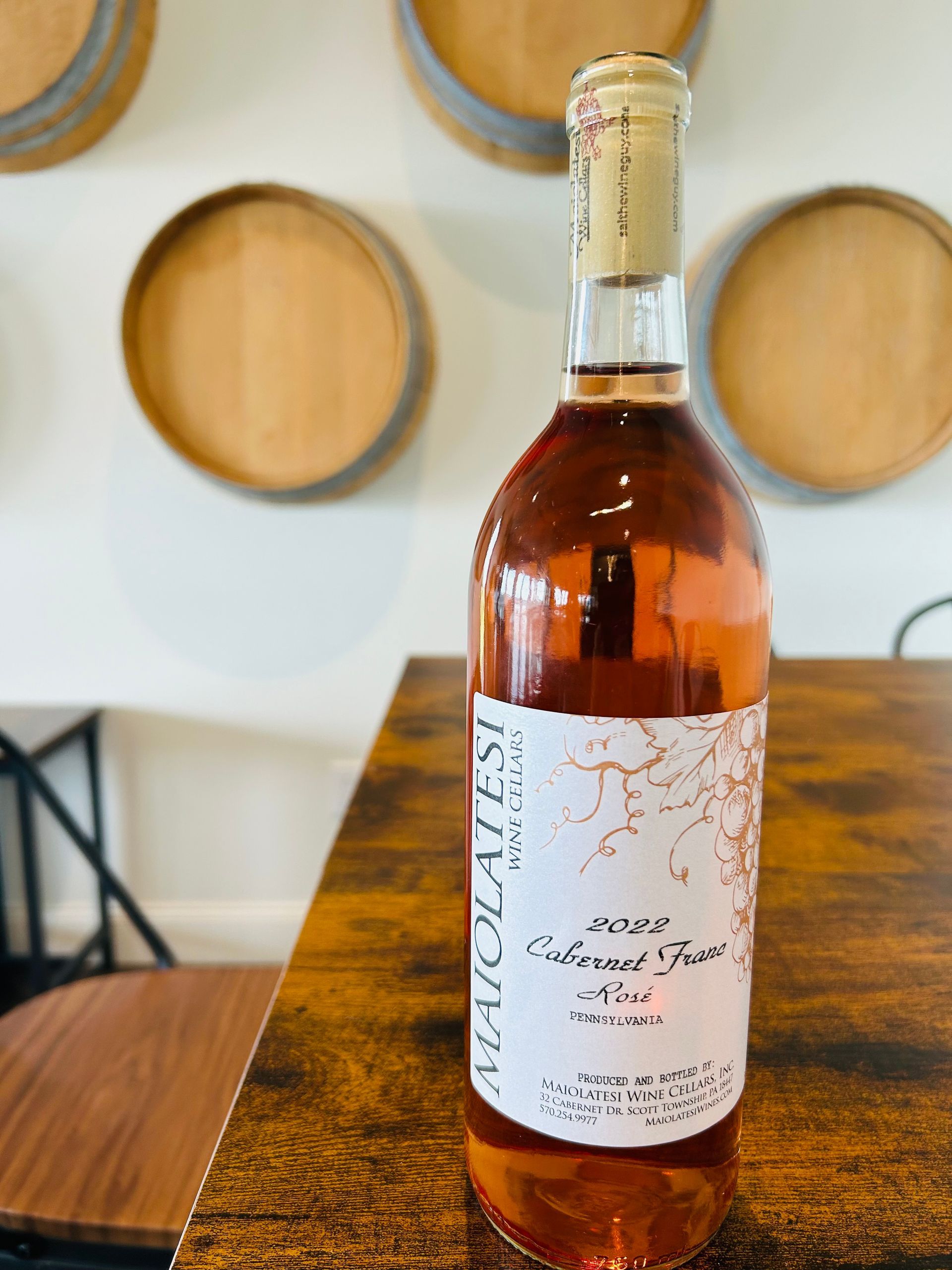A bottle of Maiolatesi's rose wine sitting on a wooden table