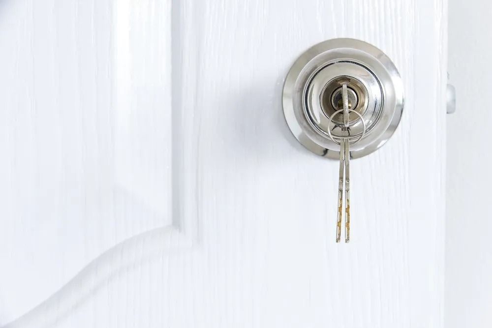Keys in a Lock on a White Door. the Key is in the Lock — CTS Locksmiths in Maroochydore, QLD