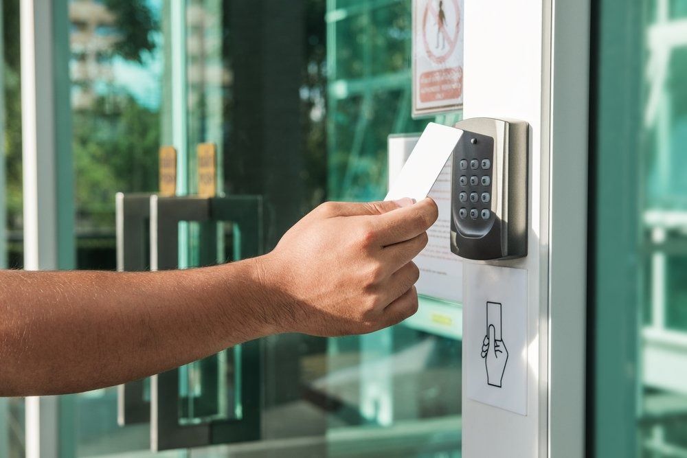 Hand Holding a White Access Card Near a Door Lock Reader, Likely for Entry — CTS Locksmiths in Kawana, QLD
