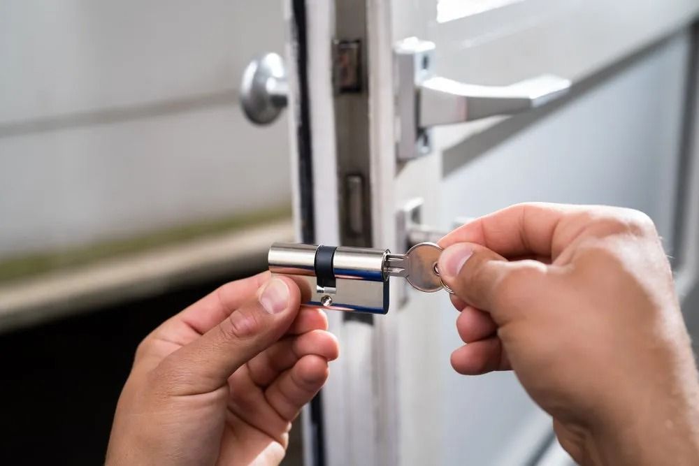 Hands Inserting a Key Into a Door Lock Cylinder for Installation — CTS Locksmiths in Maroochydore, QLD