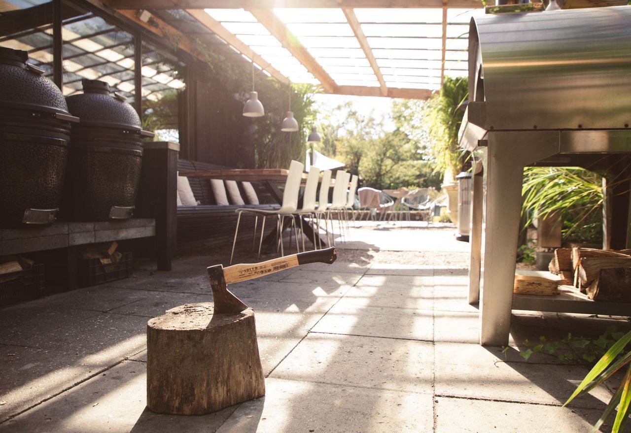 Terras met grote barbecues, zitgelegenheid buiten en een snijplank in de zon.