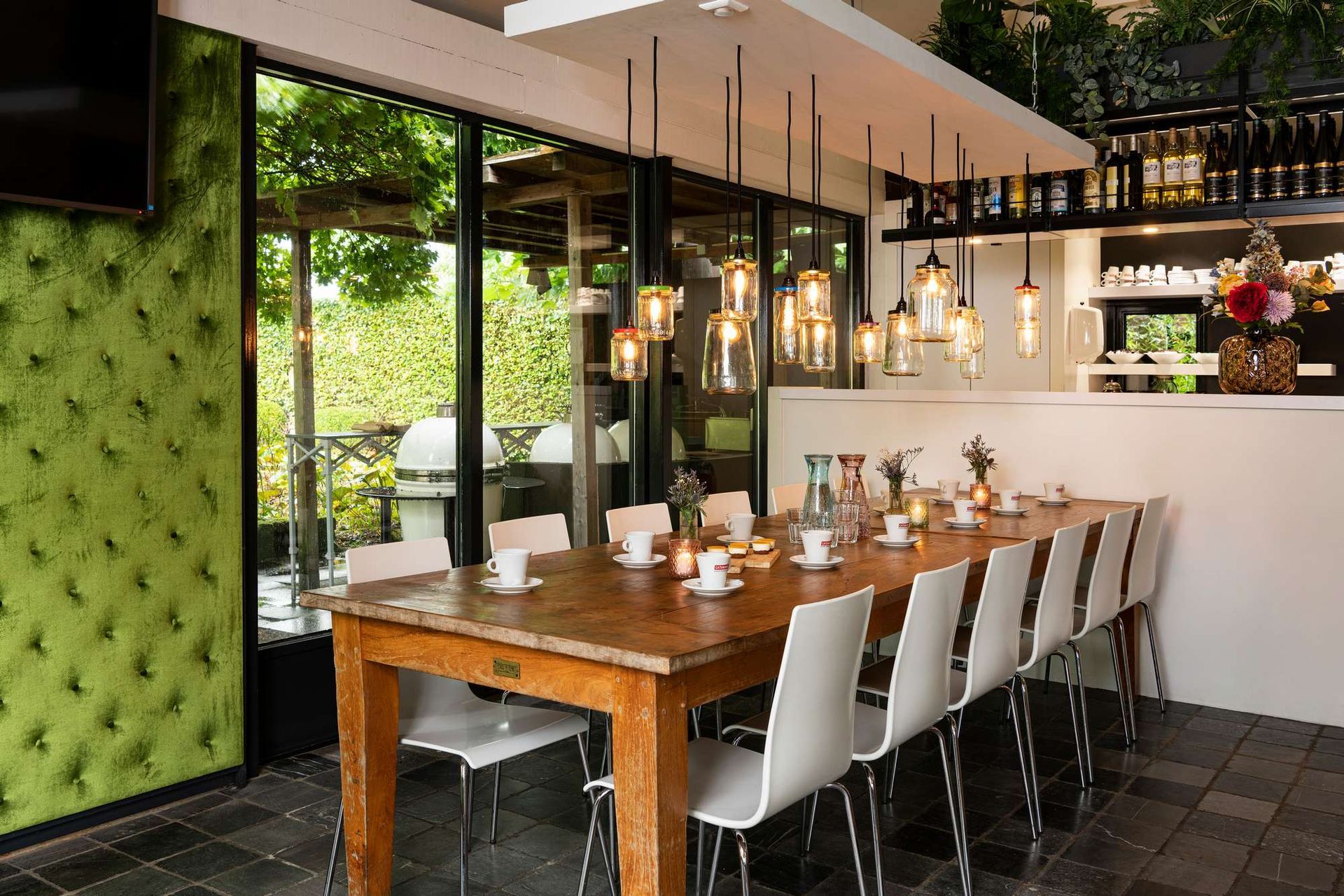 Een eetkamer met een lange houten tafel en witte stoelen