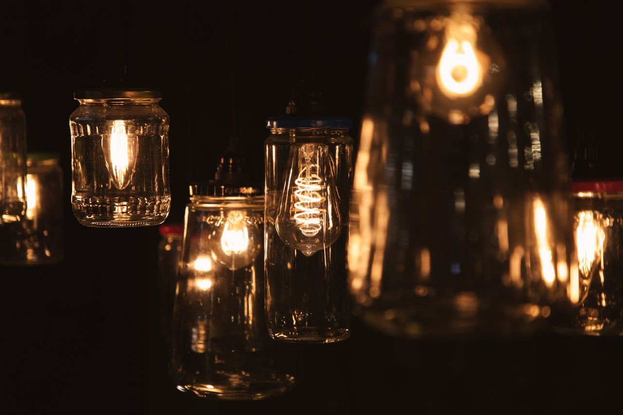 Potlantaarns met gloeiende lampjes hangen in een donkere ruimte.