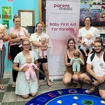 Parents in front of Parentmedic banner