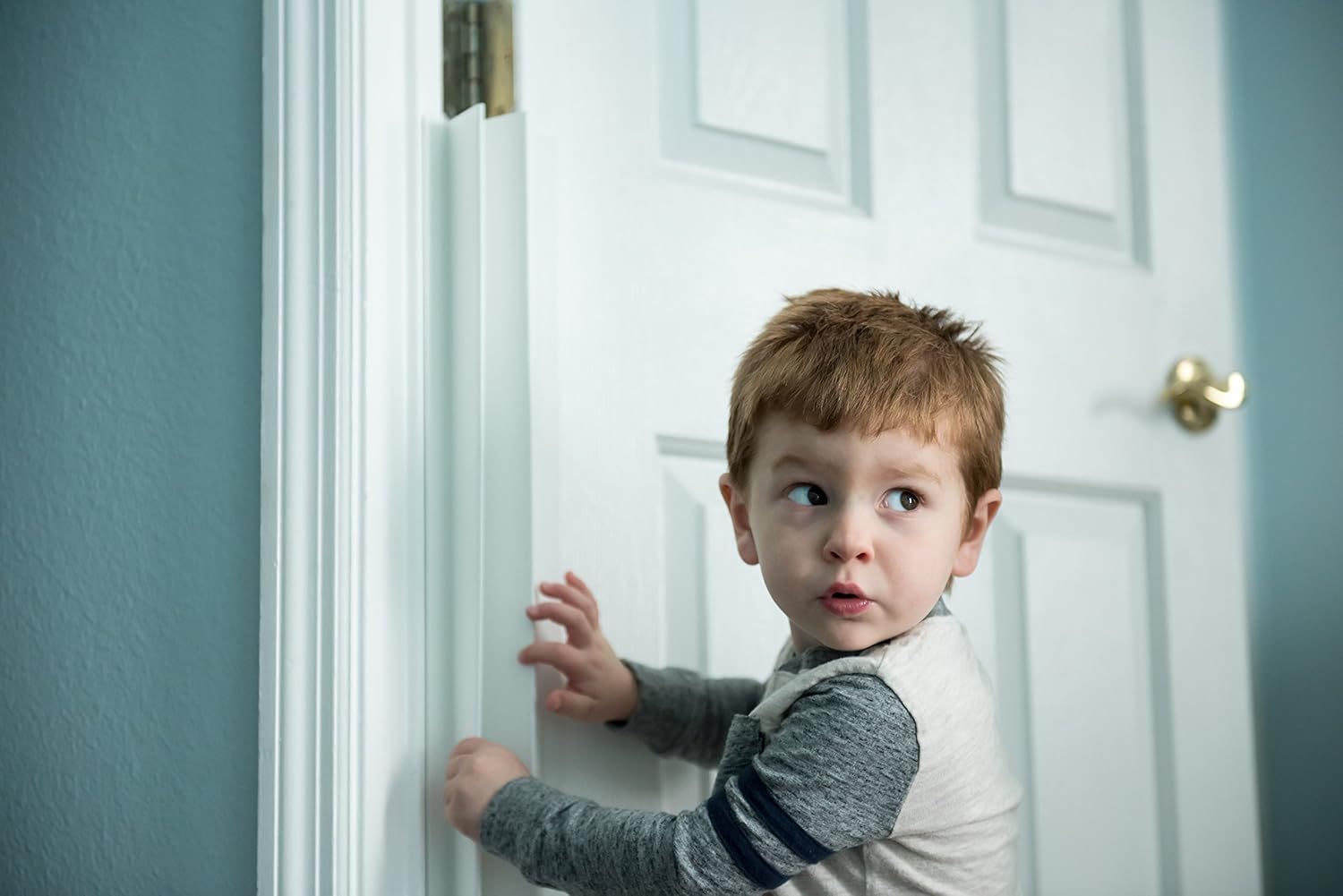 small boy closing door