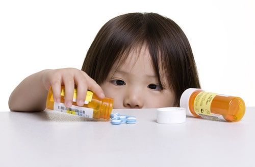 child tipping medication out of container