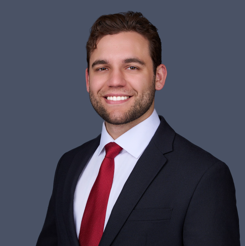 A man in a suit and tie is smiling for the camera
