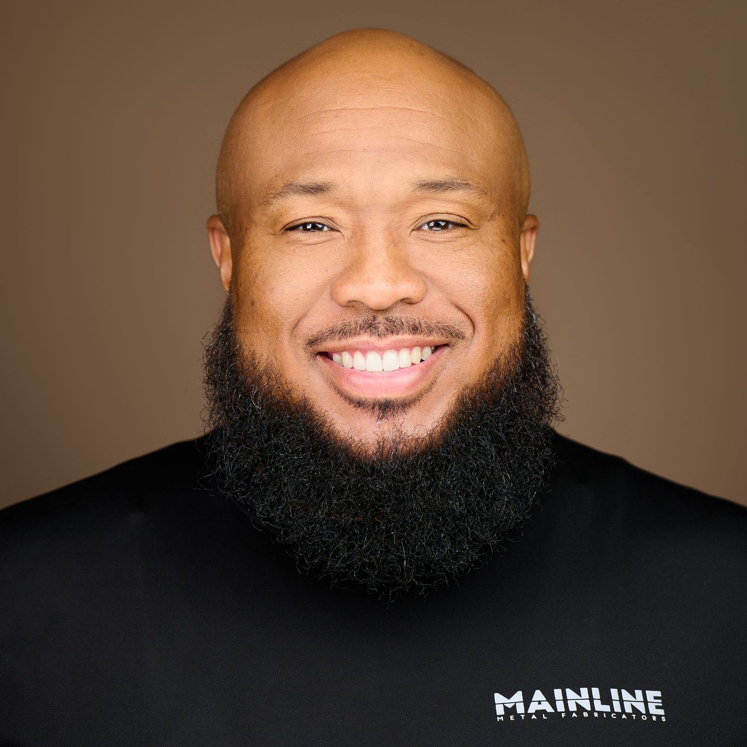 A woman in a white jacket and green shirt is smiling for the camera.