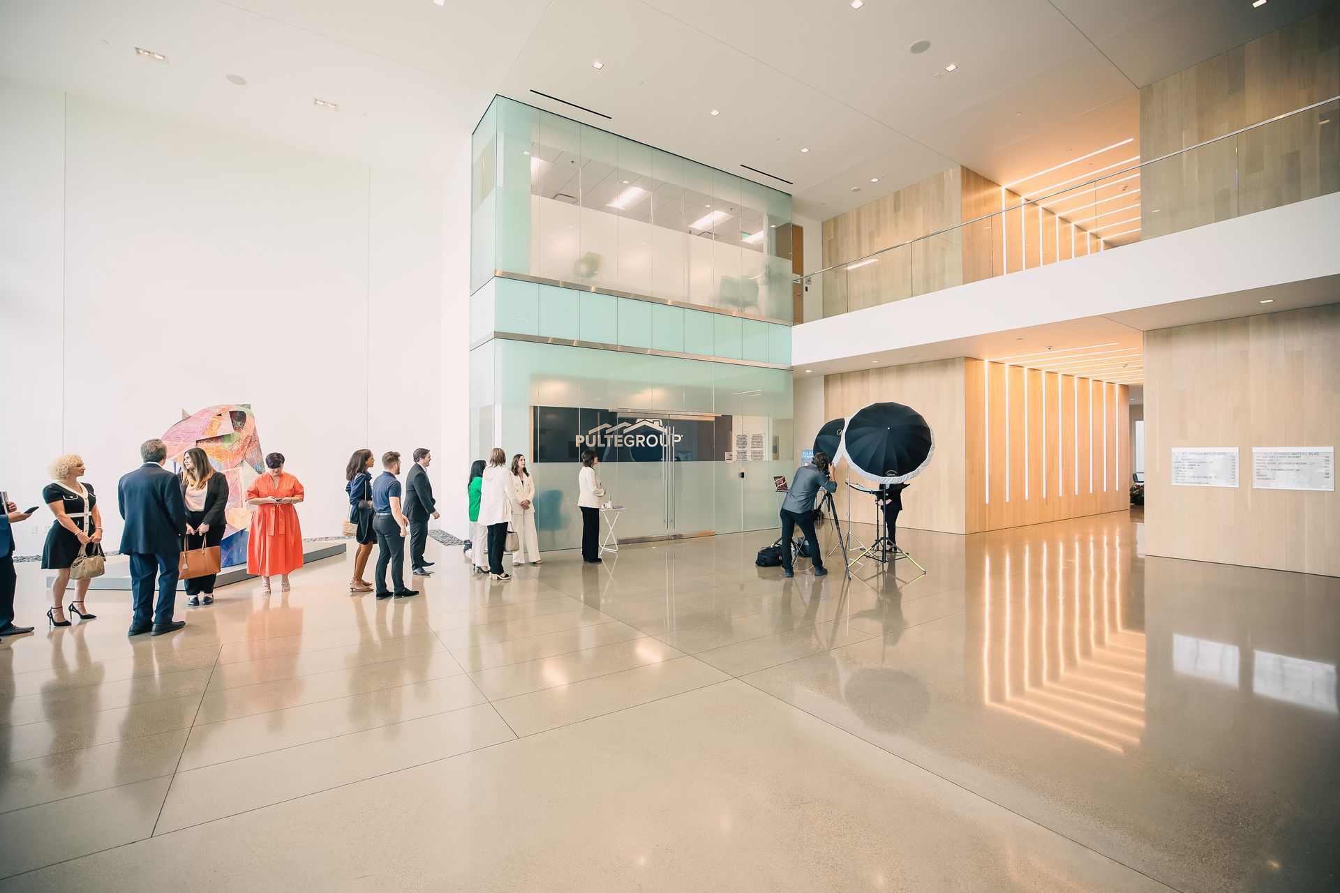 A group of people are standing in a large lobby of a building.