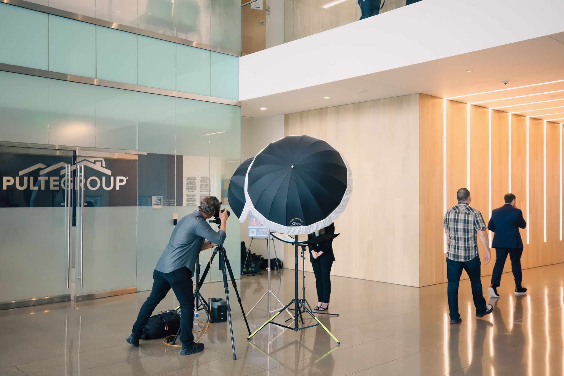A group of people are taking pictures in a lobby of a building.