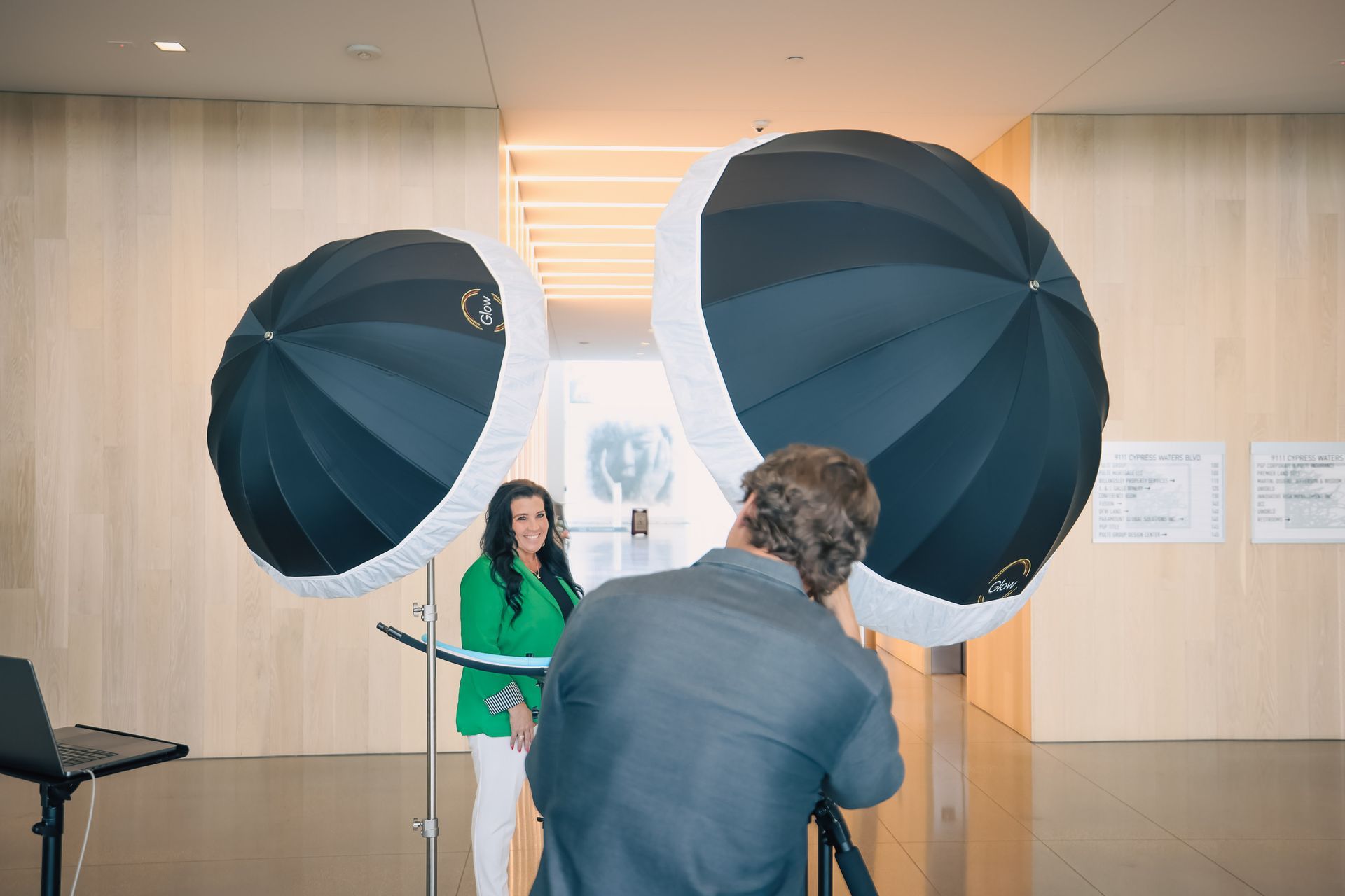 A man is taking a picture of a woman in a green jacket.