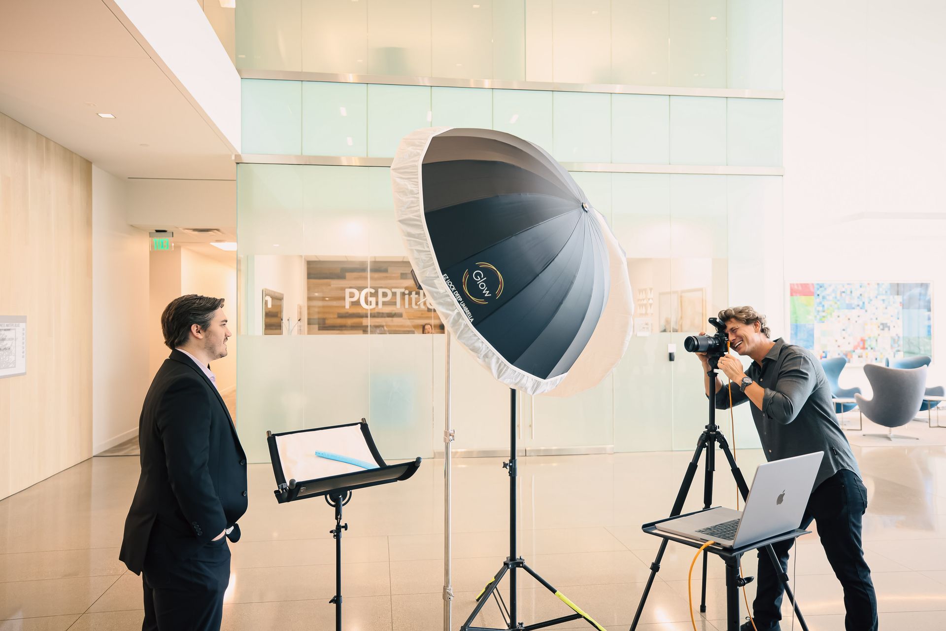 A man in a suit is taking a picture of another man in front of a camera.