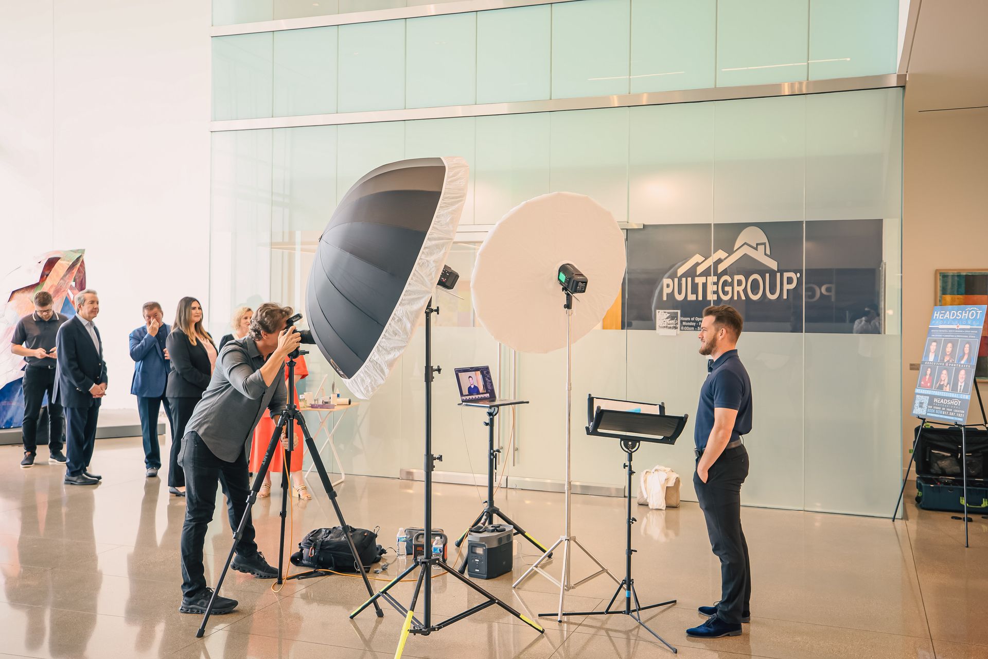 A man is taking a picture of another man in front of a camera.