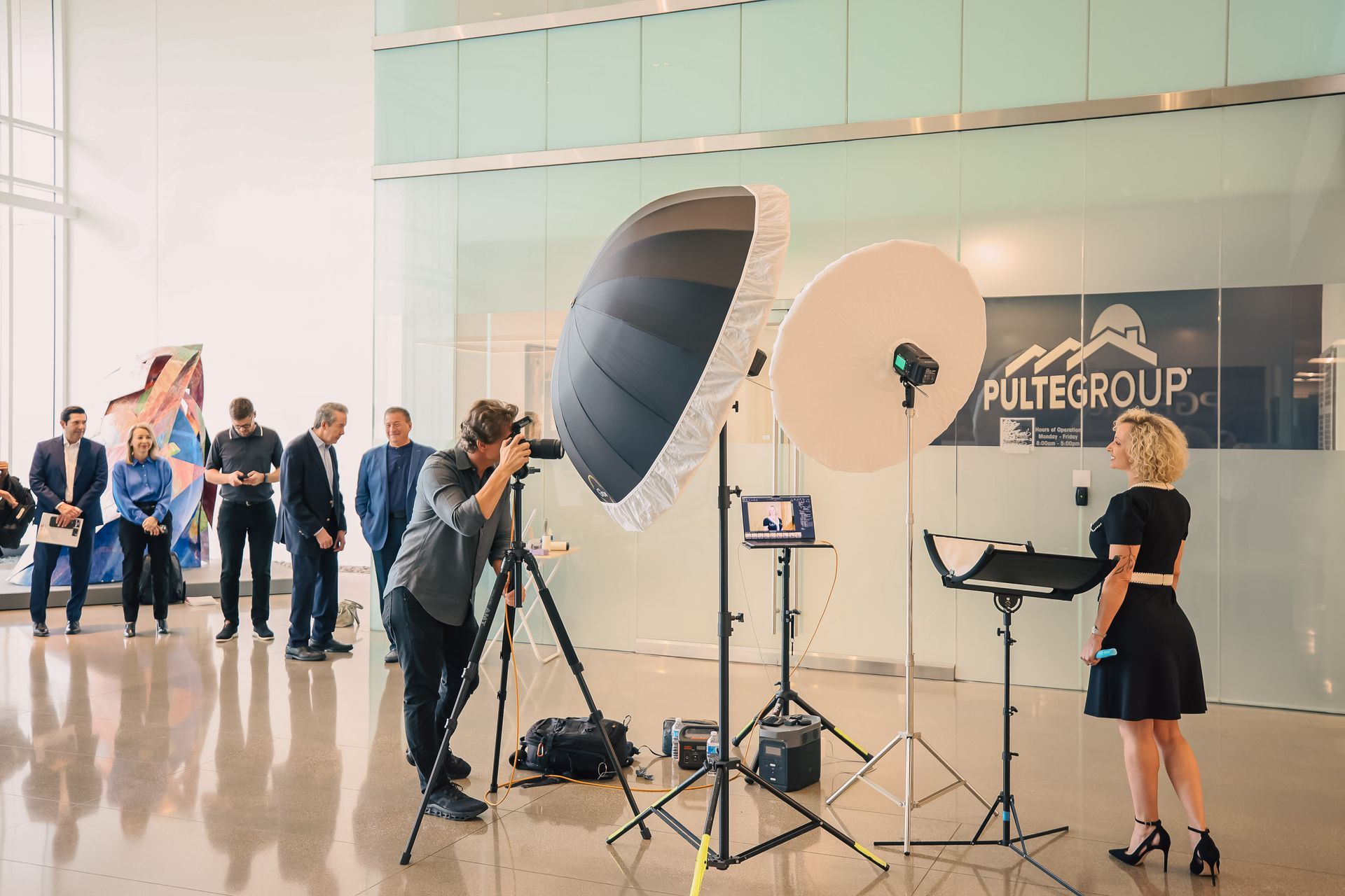 A man is taking a picture of a woman in front of a camera.
