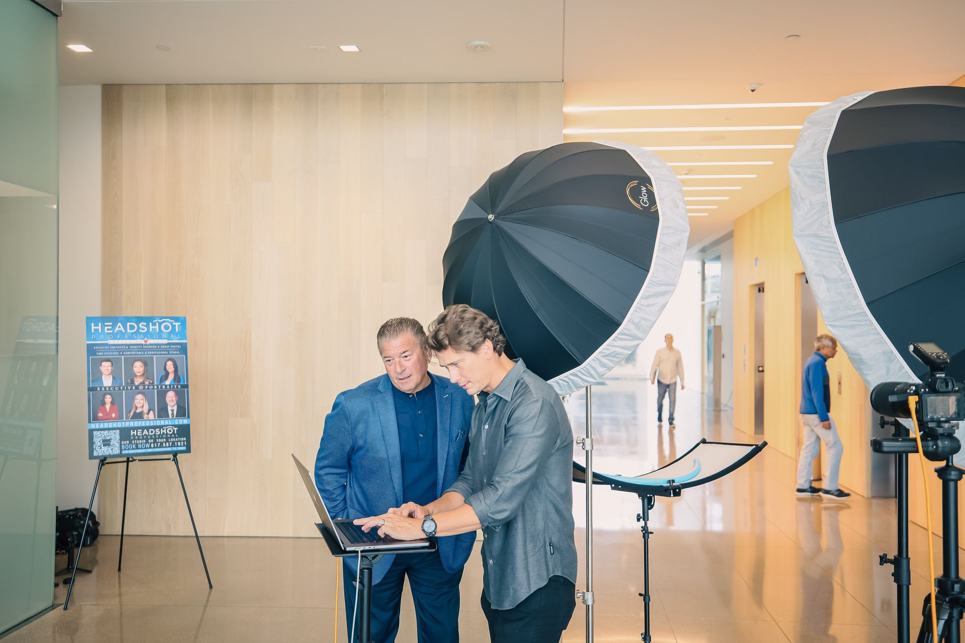 A man is taking a picture of a man in front of a godox umbrella
