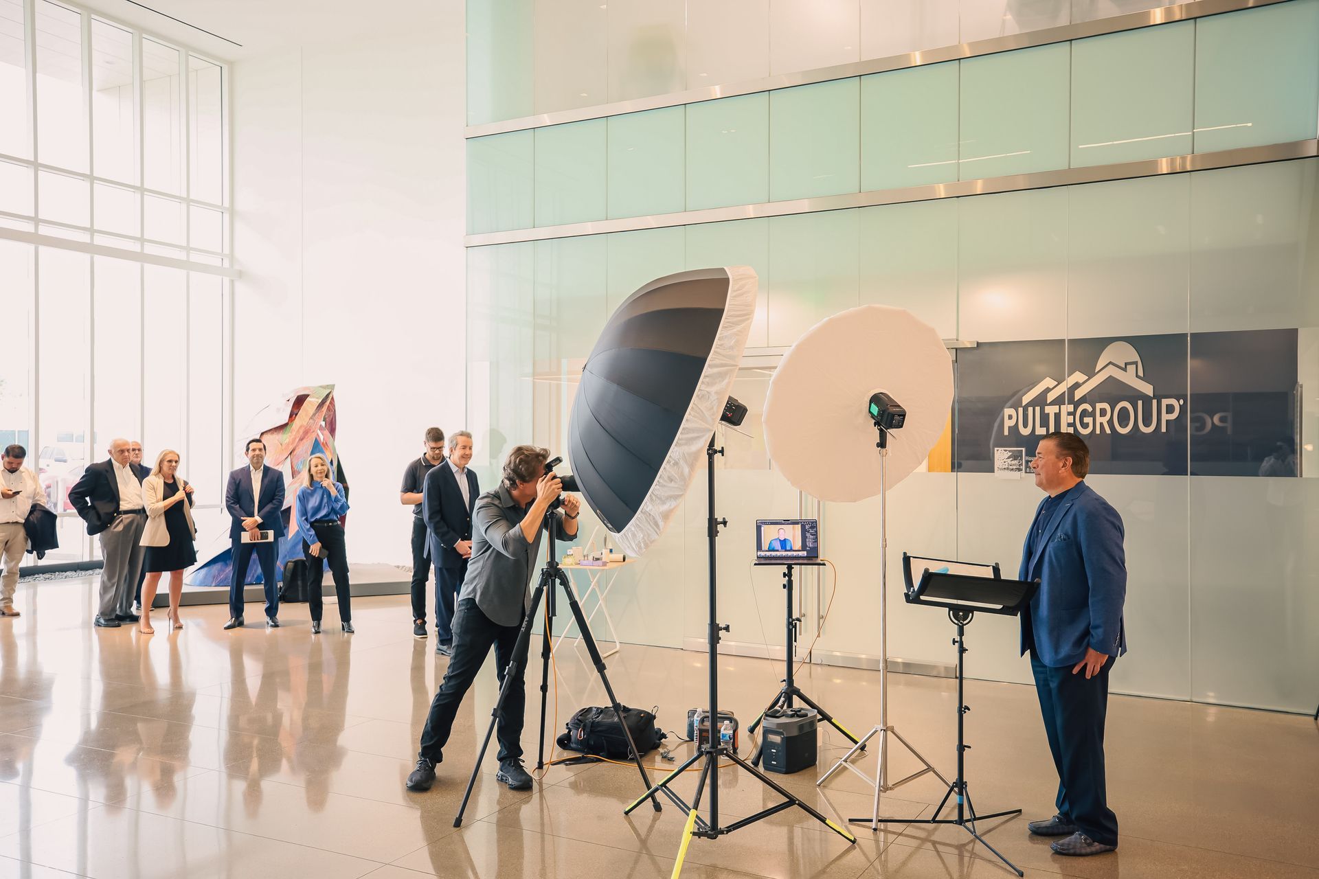 A man is standing in front of a camera while a woman takes a picture of him.