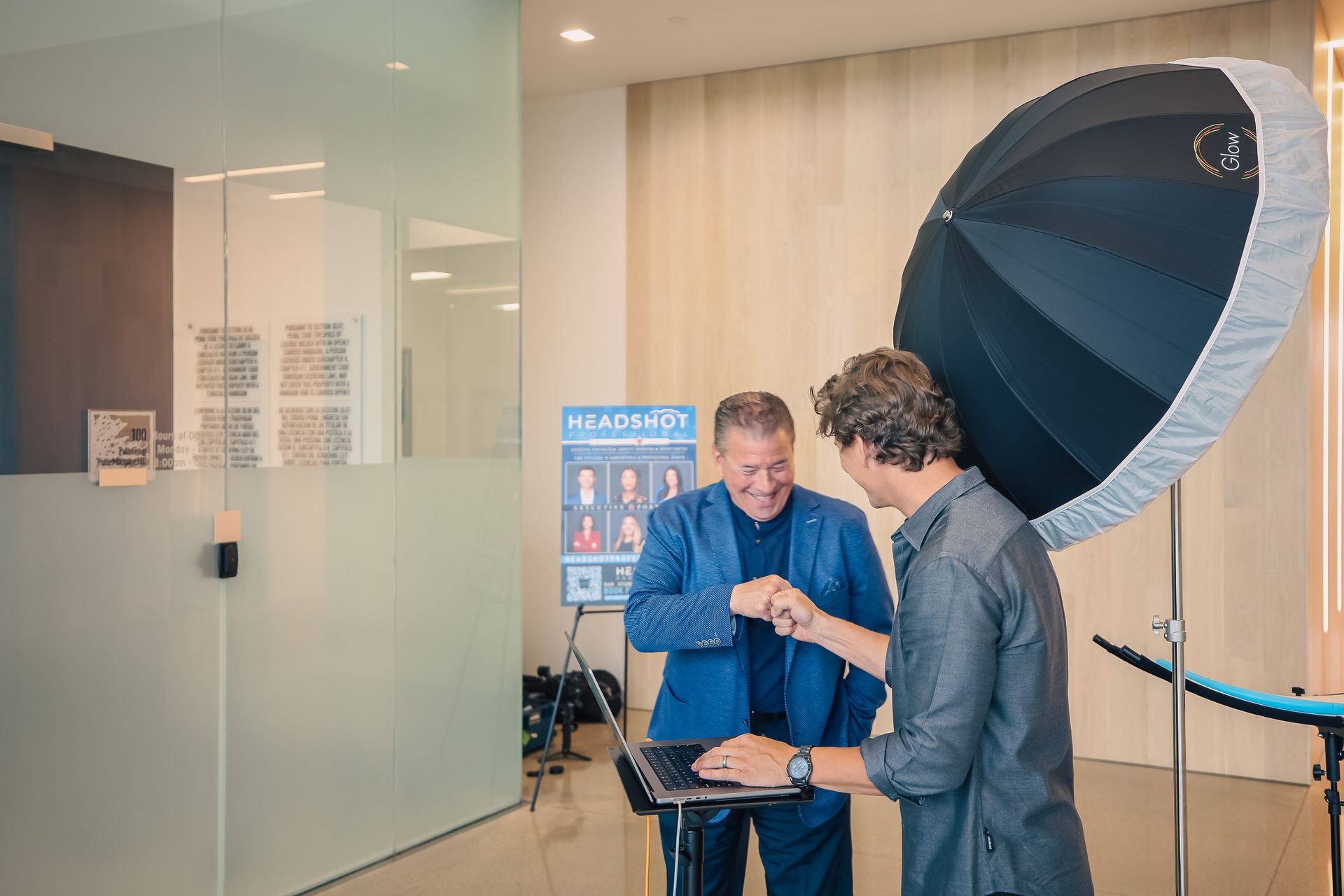 Two men are standing next to each other in front of a camera.