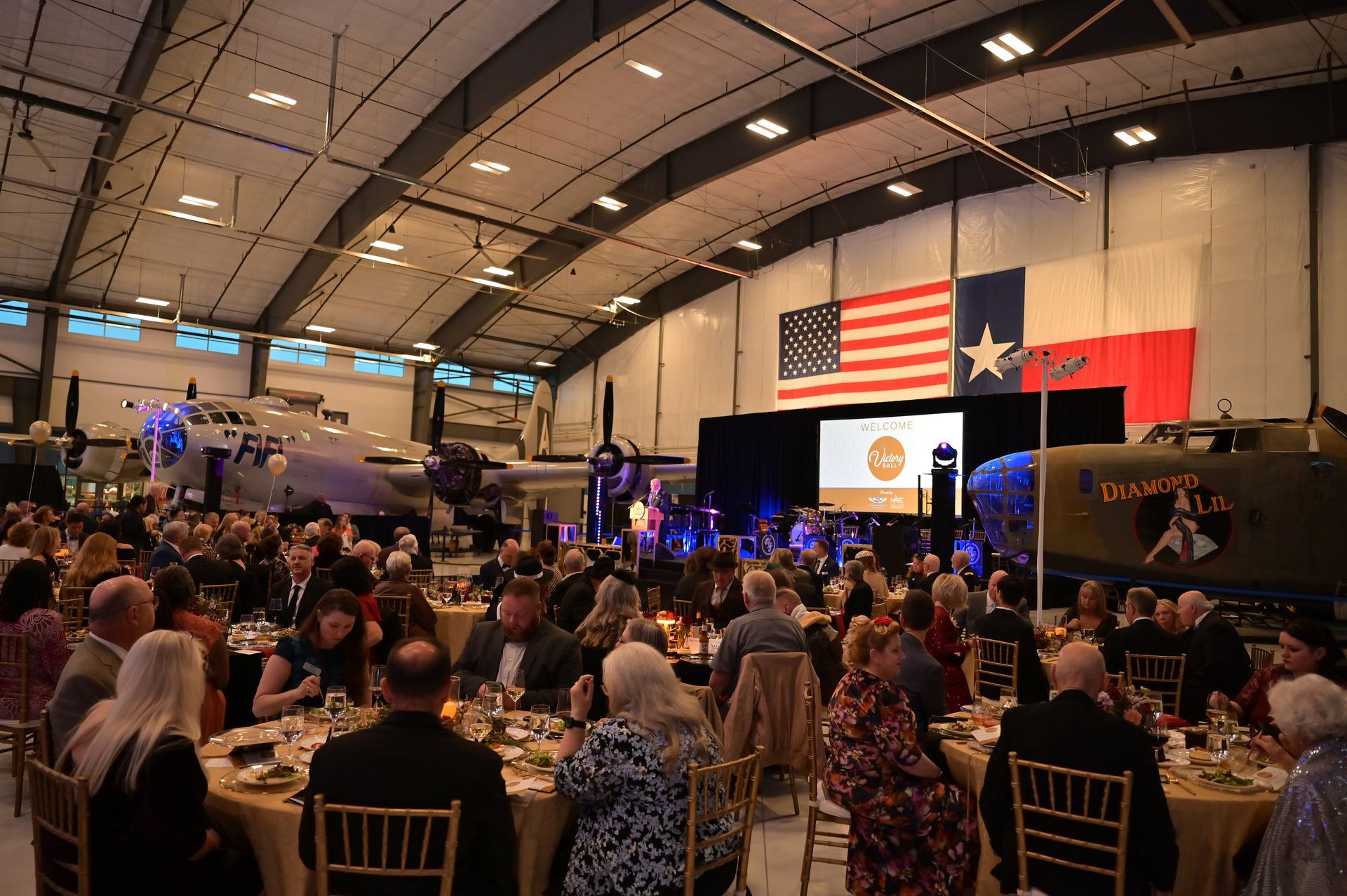 A large group of people are sitting at tables in a large room.