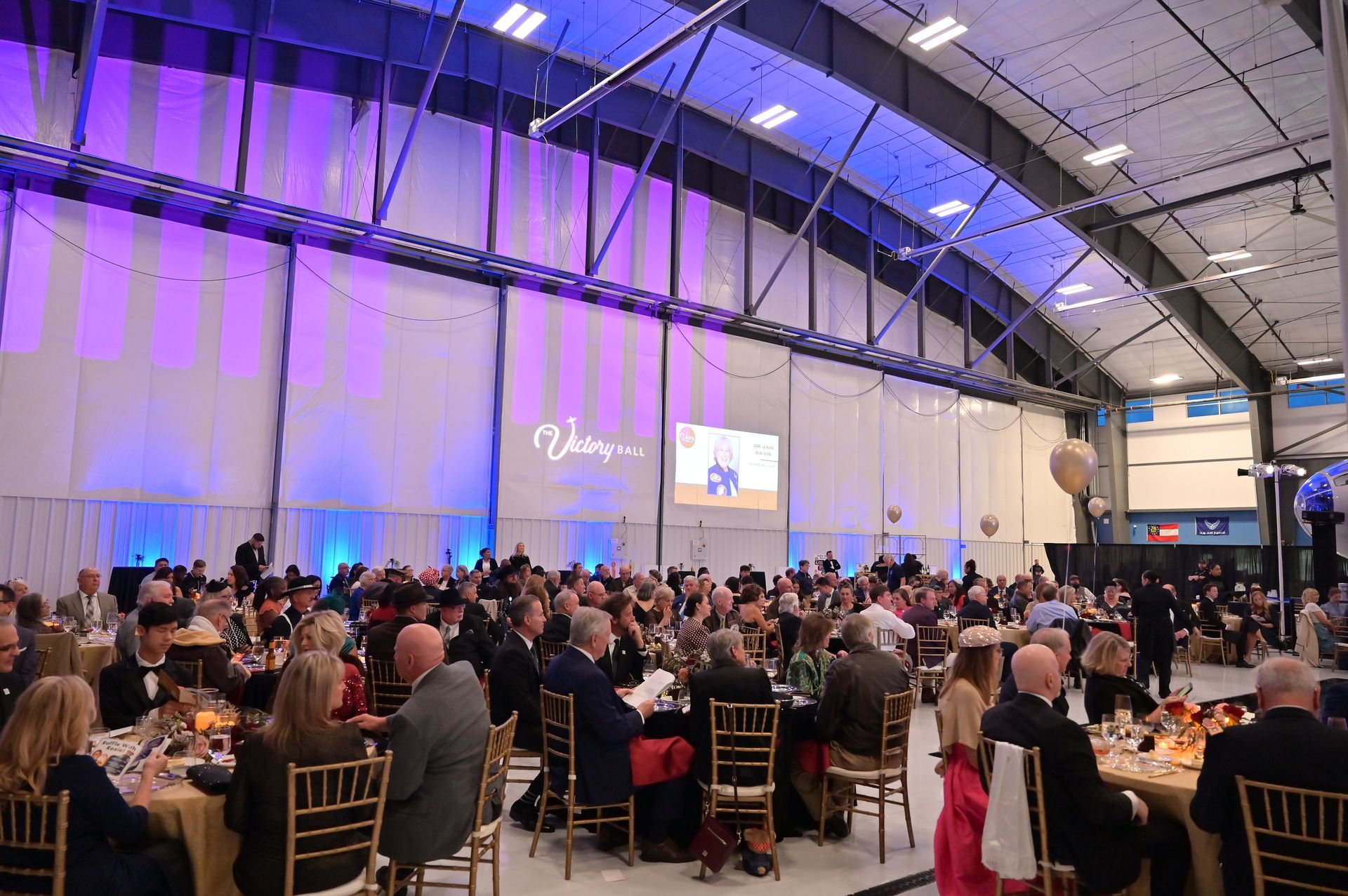 A large group of people are sitting at tables in a large room.