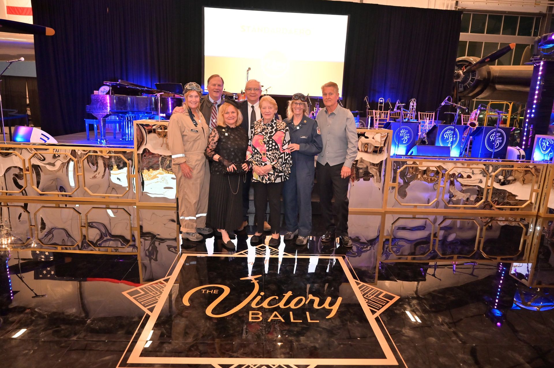 A group of people standing in front of a victory hall sign