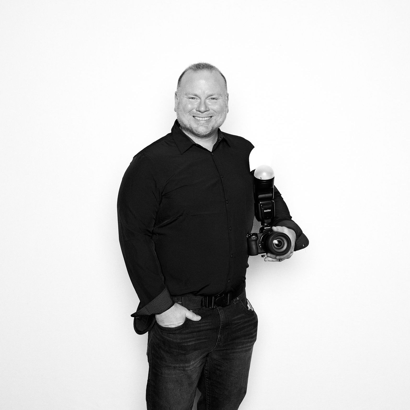 A man in a black shirt is holding a camera