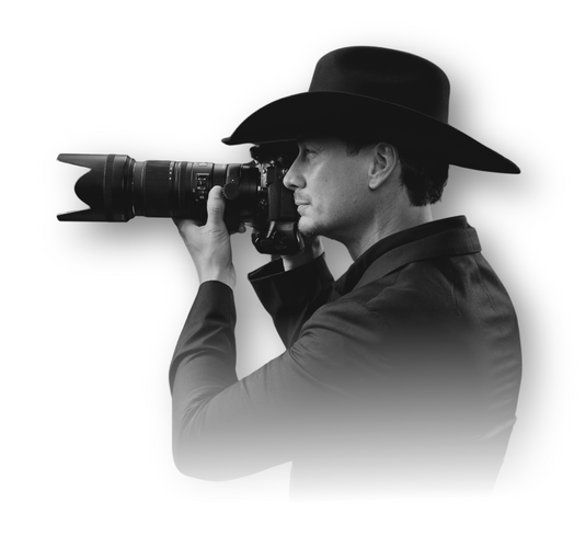 A man in a cowboy hat is taking a picture with a camera