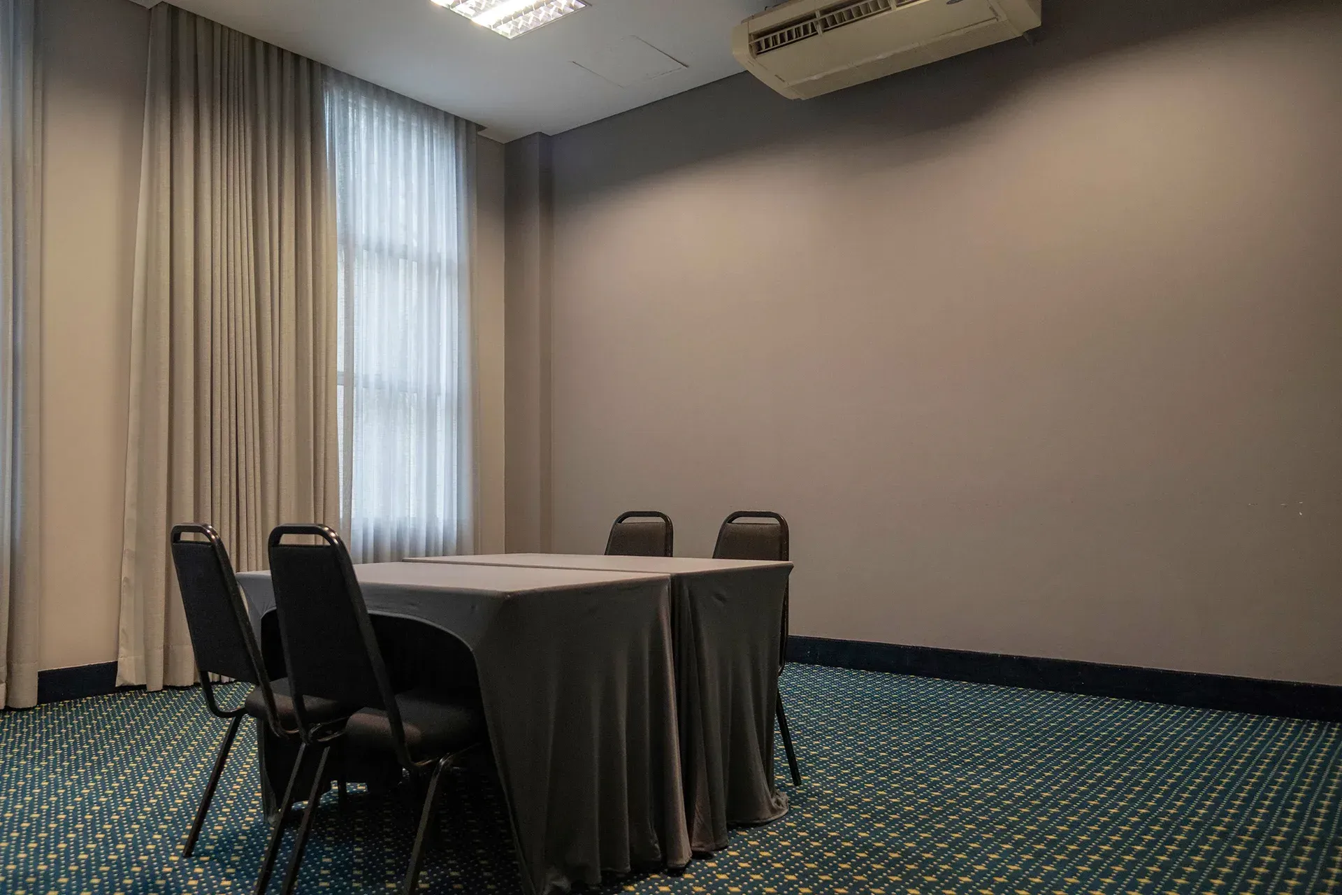 Uma sala de conferências com uma mesa e cadeiras.