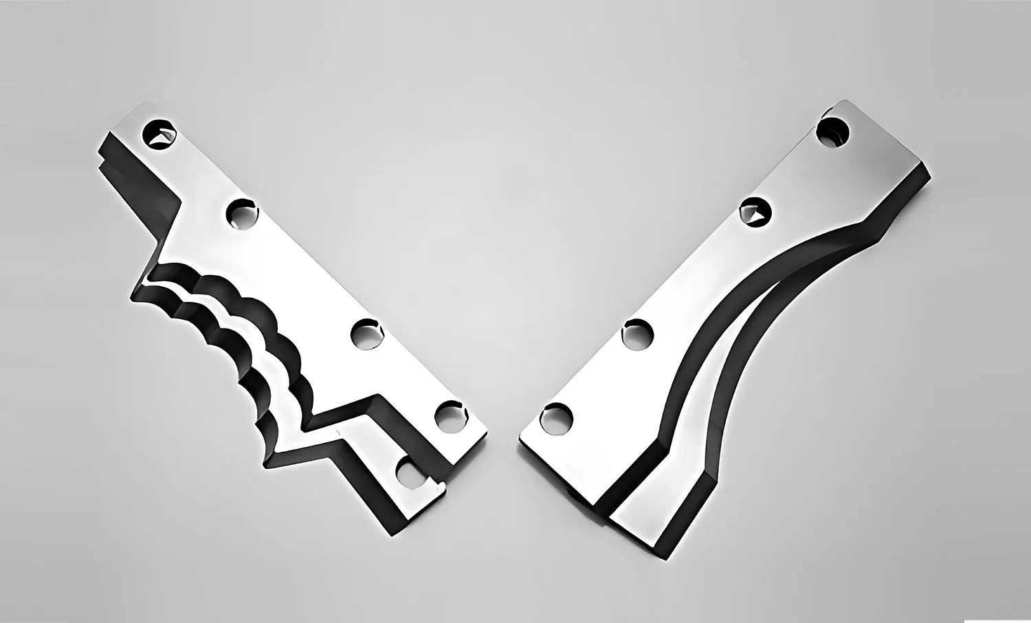 Two polished metal parts, possibly machine components, with bolt holes and unique, curved edges.