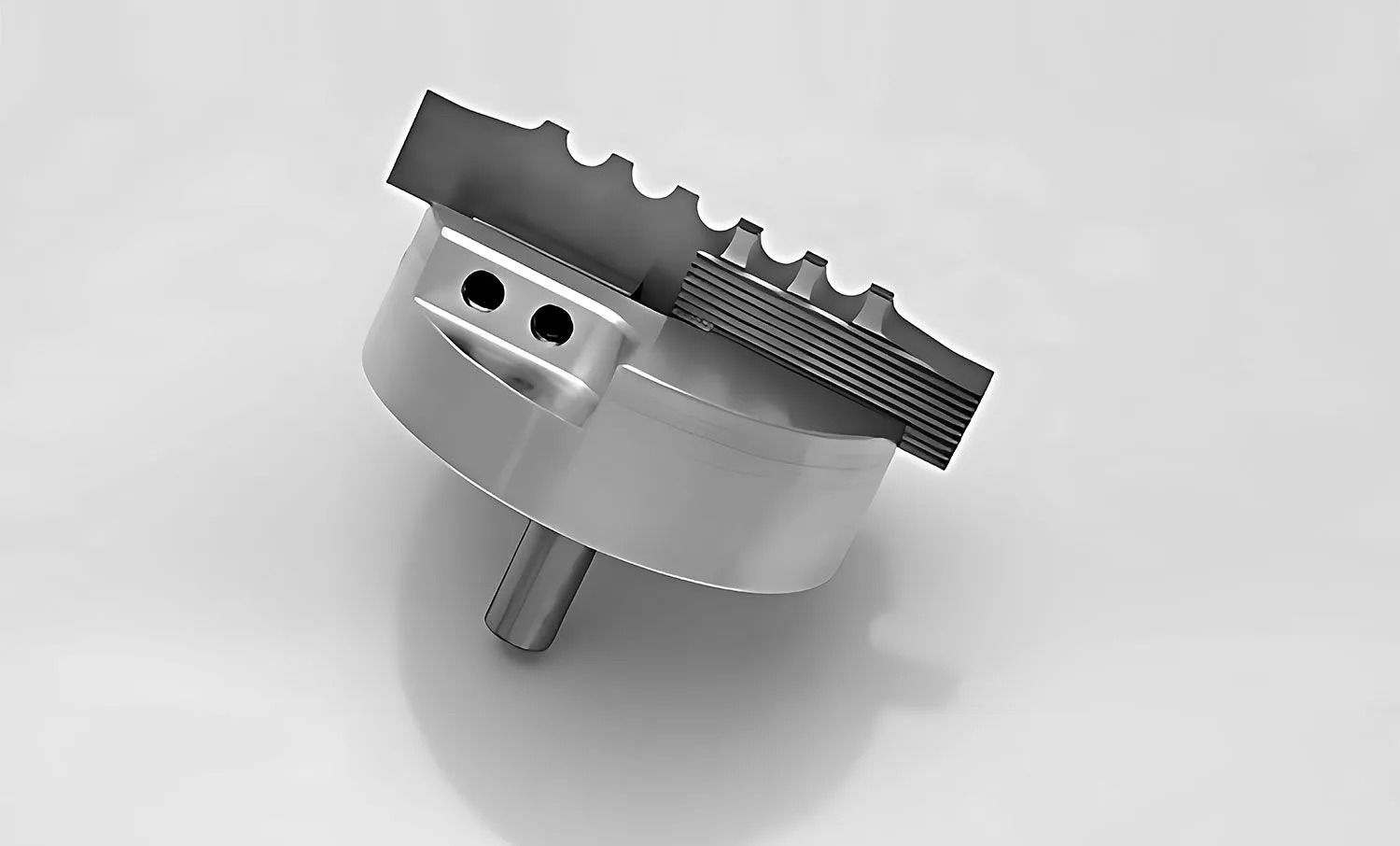 A grayscale tool featuring a circular base with a toothed metal edge and a protruding shaft.