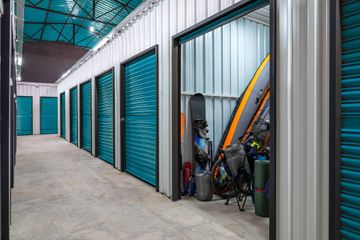 Mini storage rental units with roll-up doors offering secure indoor storage space.