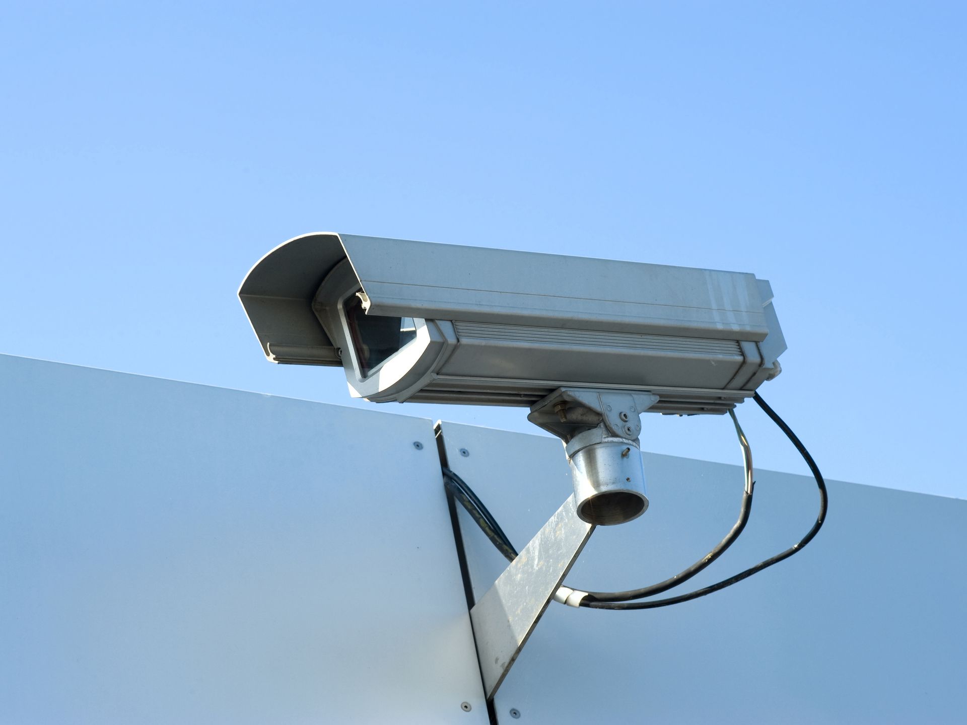 Mounted surveillance camera and sky.