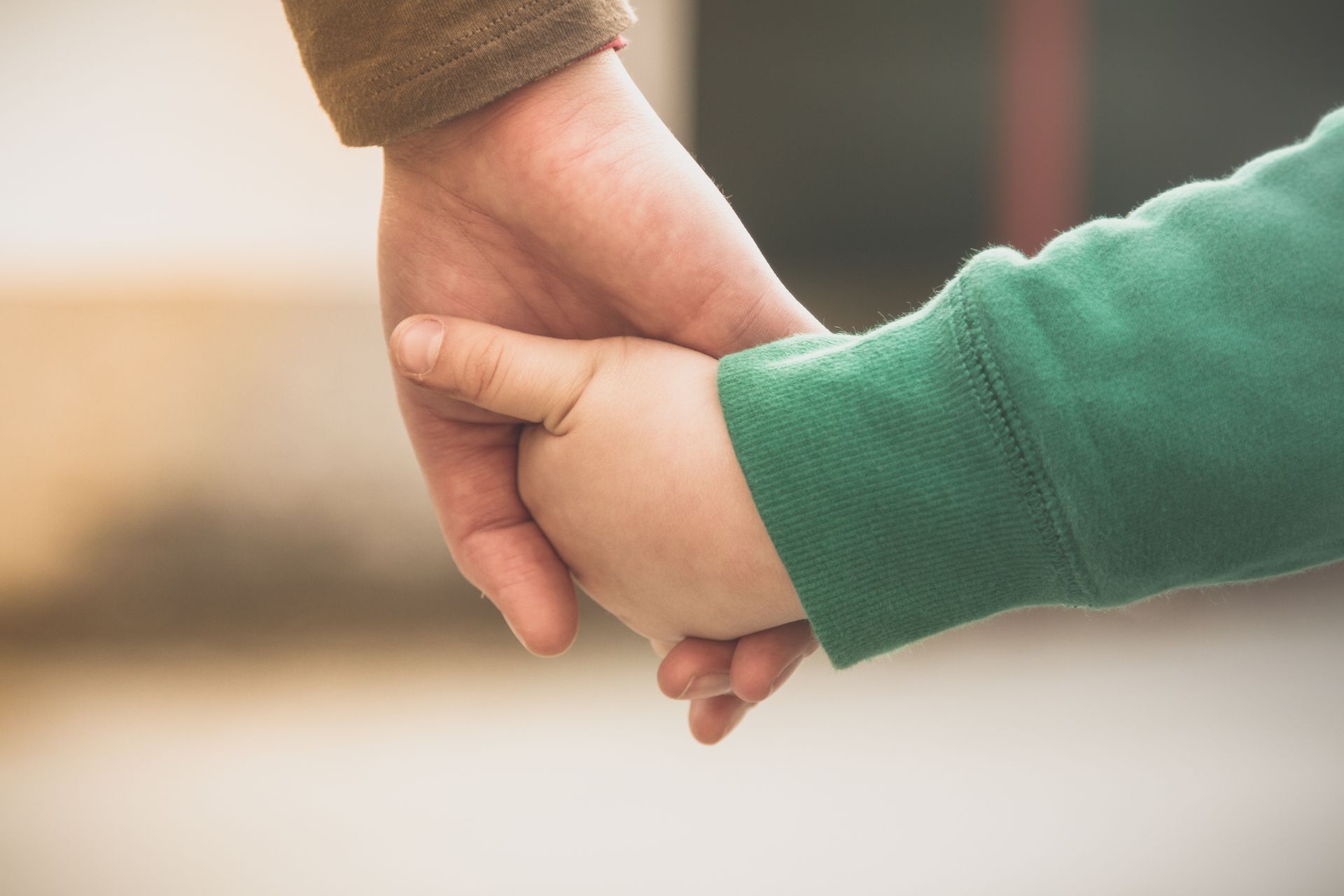 Un gros plan d'une personne tenant la main d'un enfant.