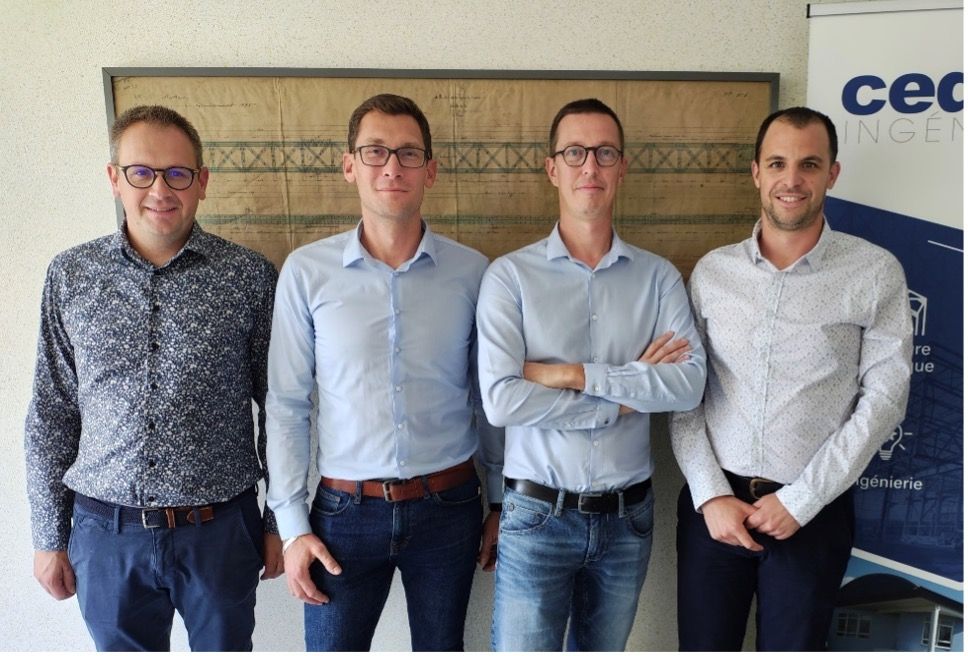Un groupe de quatre hommes debout l'un à côté de l'autre, les bras croisés.