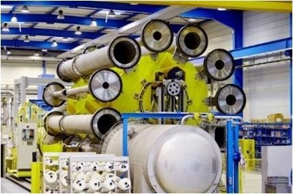 Une grande machine dans une usine avec beaucoup de tuyaux
