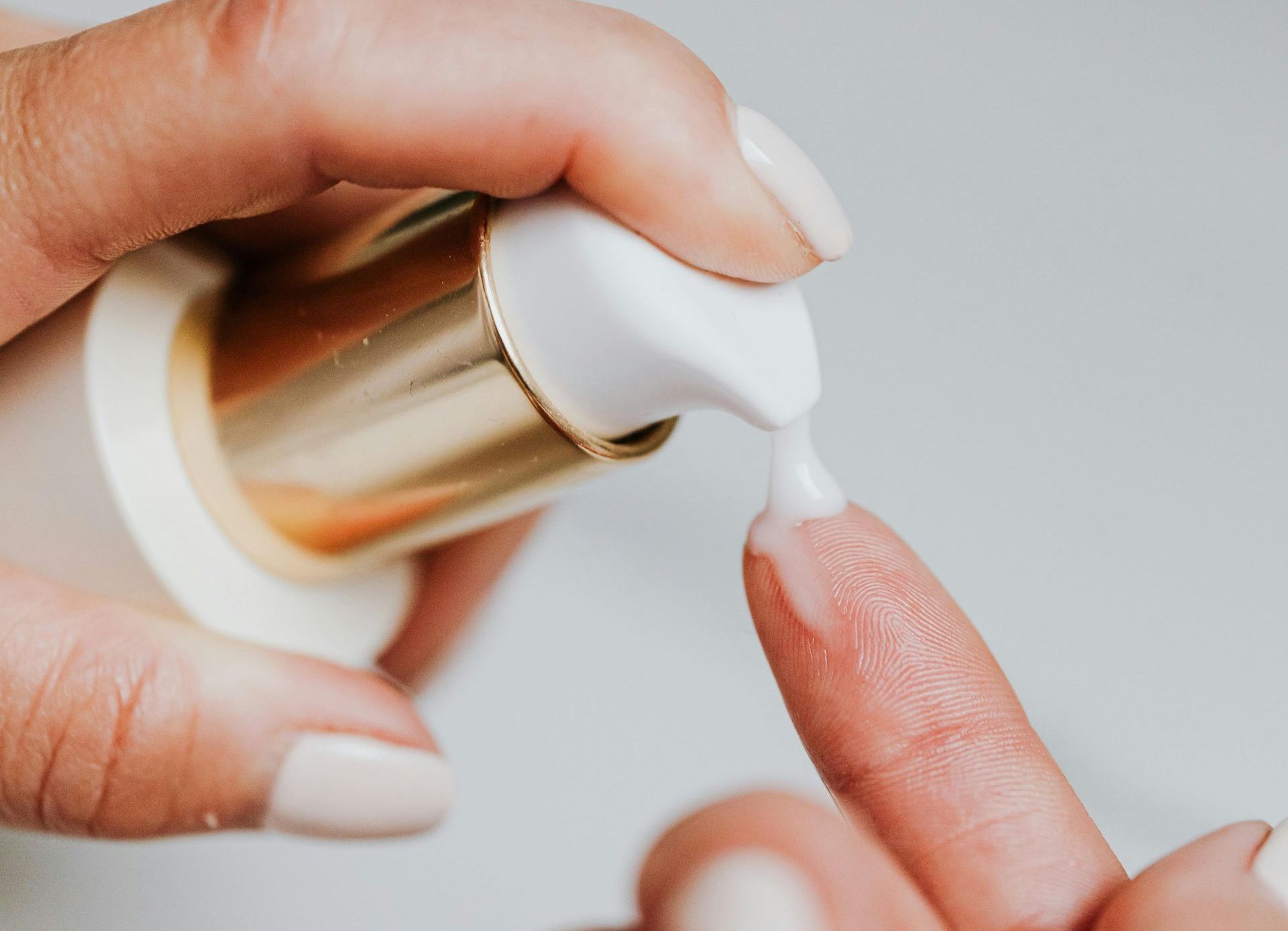 Une femme applique de la lotion sur son doigt.