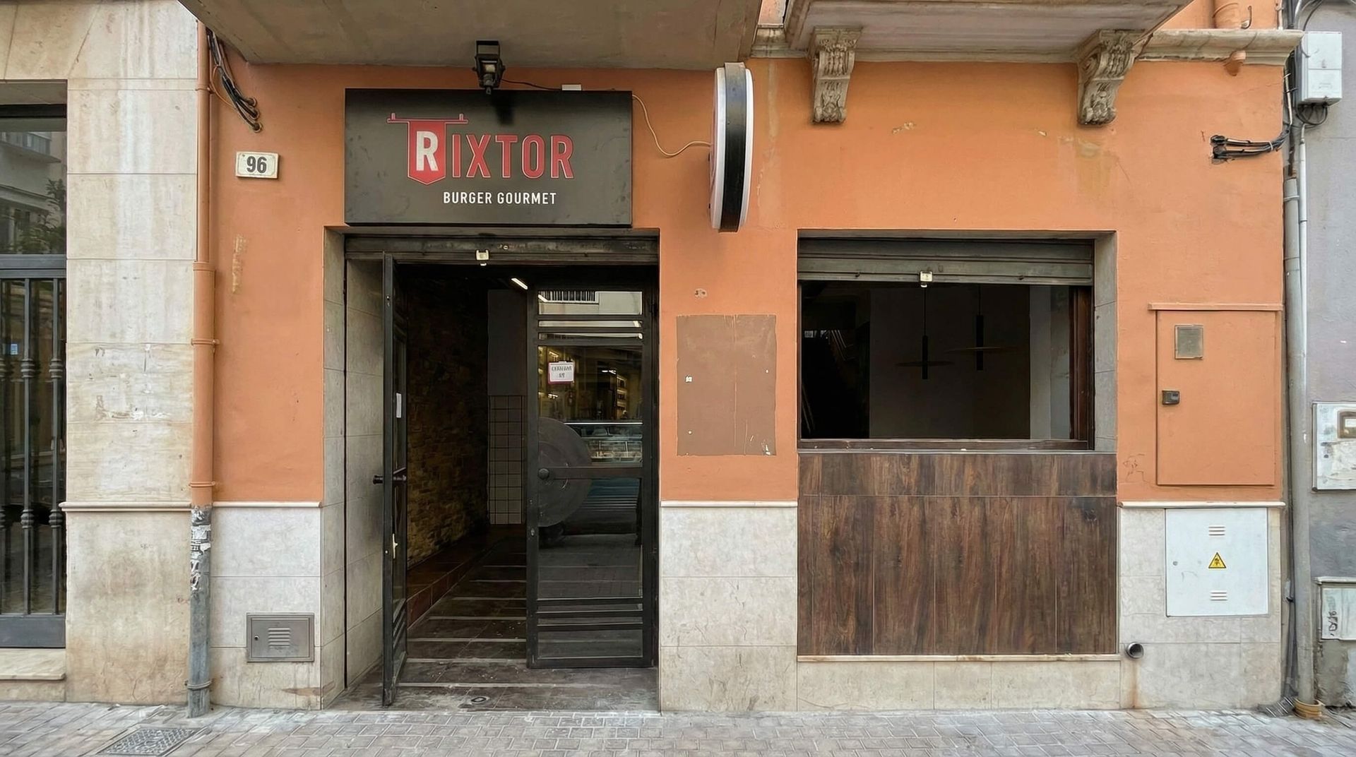 Exterior del restaurante con la puerta abierta y el cartel 