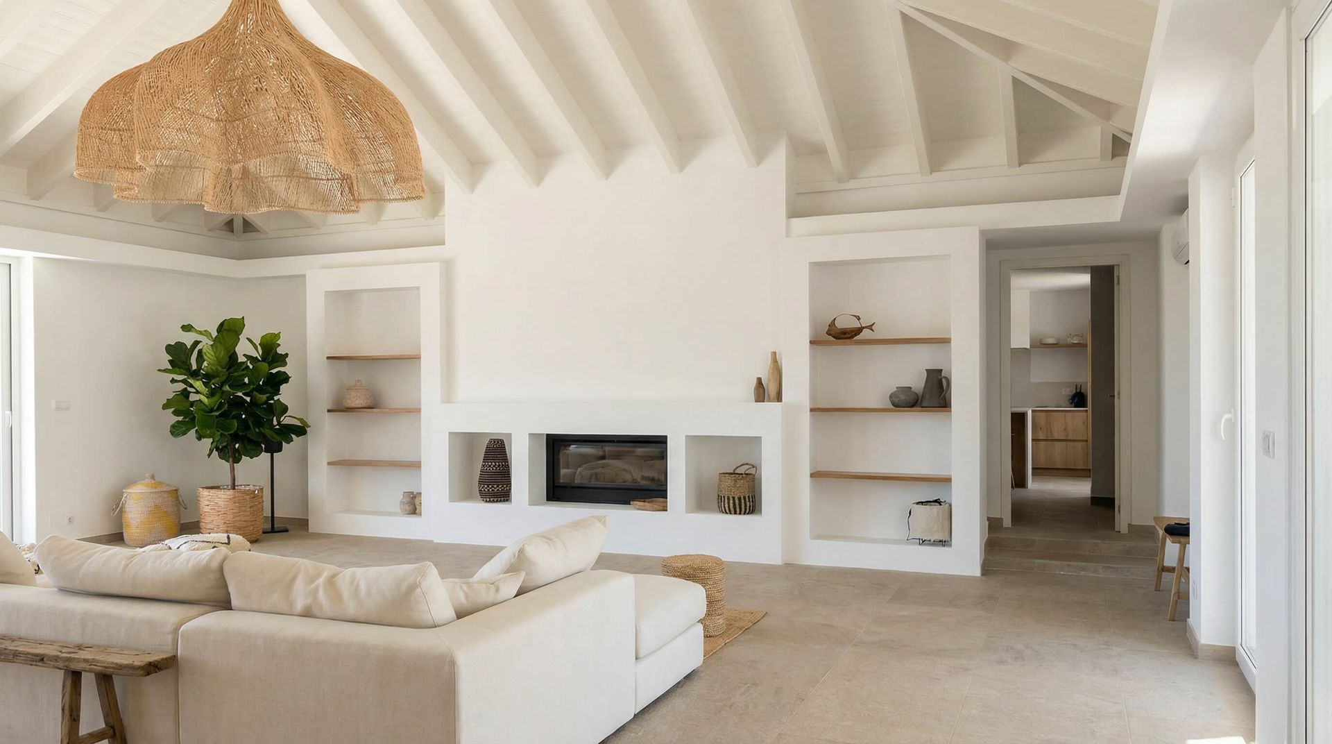 Sala de estar blanca brillante con muebles de tonos neutros, chimenea, estantes empotrados y una gran lámpara tejida.