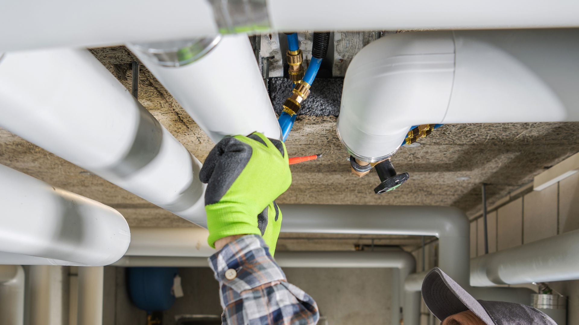A man is working on a pipe in a building.